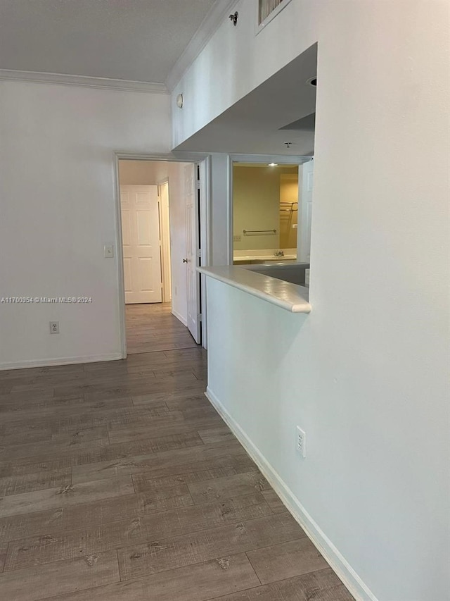 hall with wood-type flooring and ornamental molding