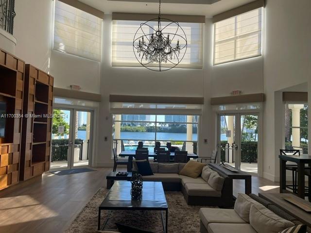 living room featuring hardwood / wood-style flooring, plenty of natural light, a water view, and french doors