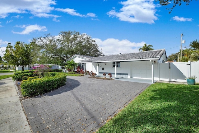 ranch-style house with a garage and a front lawn