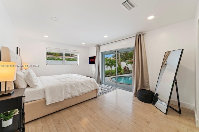 bedroom featuring light wood-type flooring, access to outside, and multiple windows