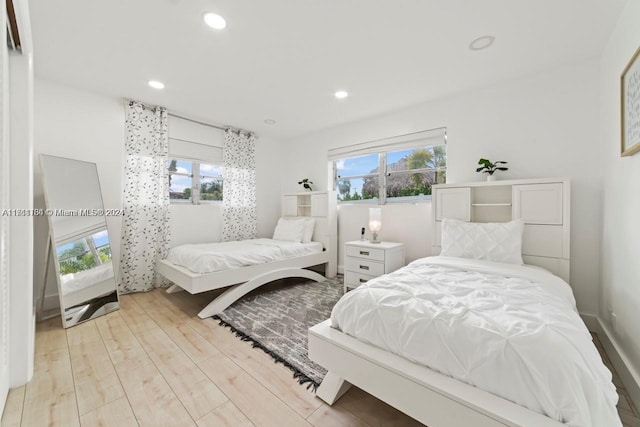 bedroom with multiple windows and light wood-type flooring