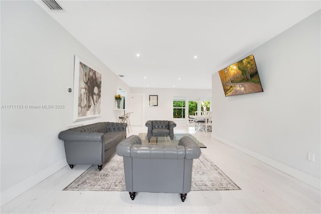 living area with baseboards, visible vents, and recessed lighting