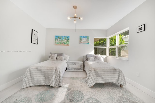 bedroom featuring a chandelier and baseboards