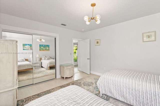 bedroom featuring a closet, visible vents, baseboards, and an inviting chandelier