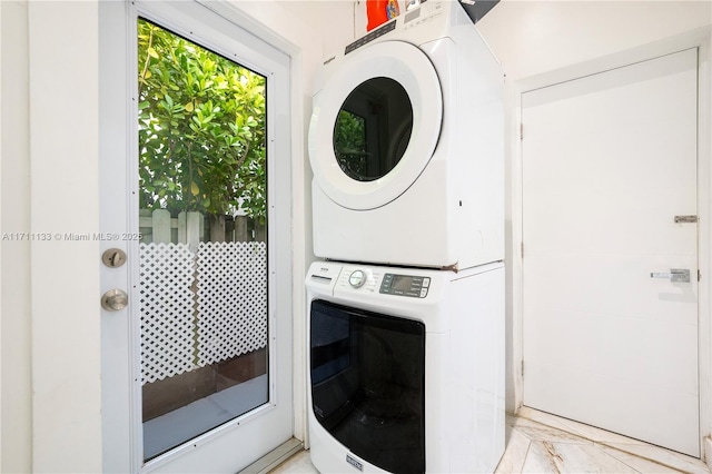 laundry room featuring stacked washer / drying machine, laundry area, and marble finish floor