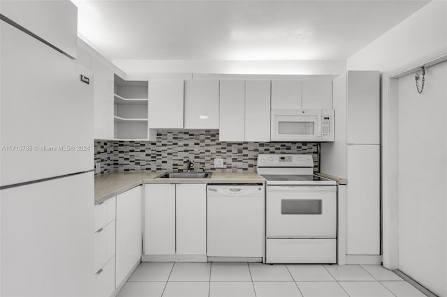 kitchen featuring sink, light tile patterned floors, tasteful backsplash, white appliances, and white cabinets