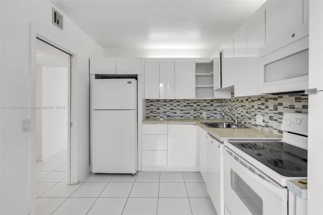 kitchen featuring sink, light tile patterned floors, tasteful backsplash, white appliances, and white cabinets