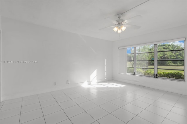 tiled empty room featuring ceiling fan