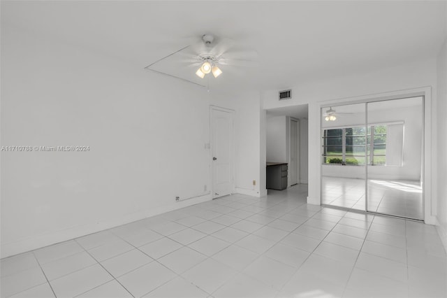 tiled spare room with ceiling fan