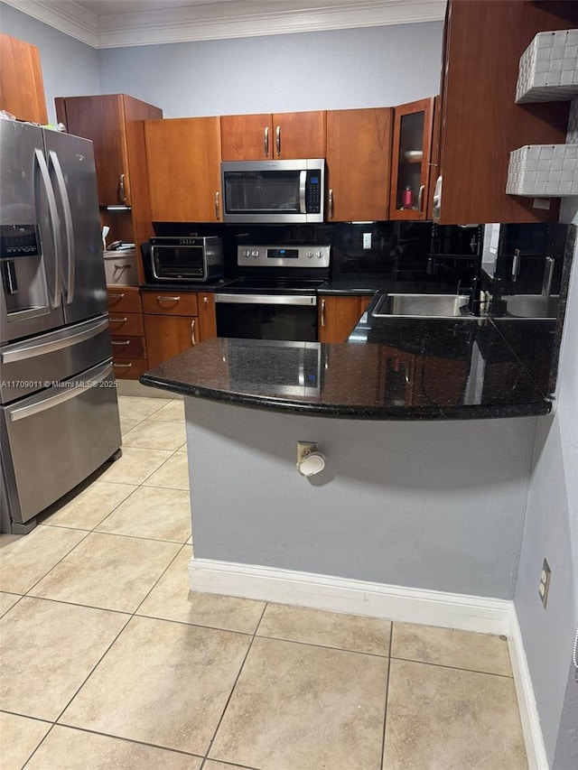 kitchen featuring dark stone countertops, sink, light tile patterned floors, and appliances with stainless steel finishes