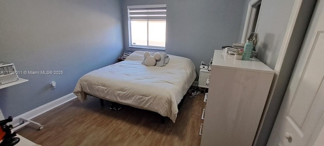 bedroom with dark hardwood / wood-style flooring