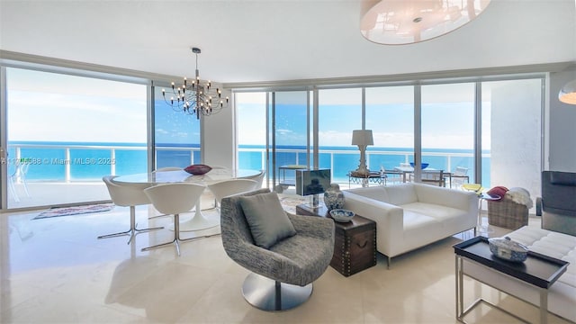 living room with a water view, a chandelier, and a wall of windows