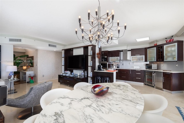 dining space with ornamental molding, beverage cooler, and a chandelier