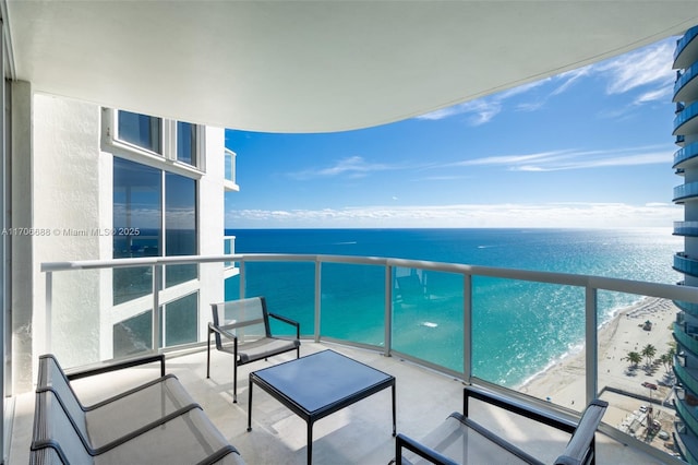 balcony featuring a water view and a beach view