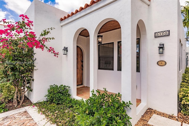 view of exterior entry featuring covered porch