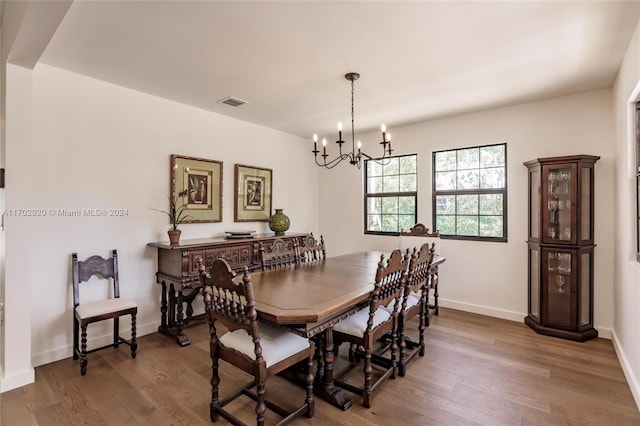 dining area featuring wood-type flooring and an inviting chandelier