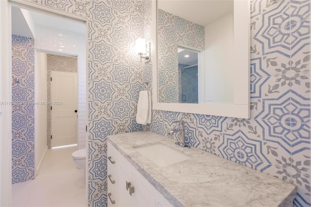 bathroom featuring a shower, tile patterned floors, vanity, and toilet