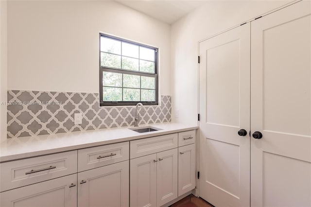 kitchen featuring backsplash, white cabinetry, and sink