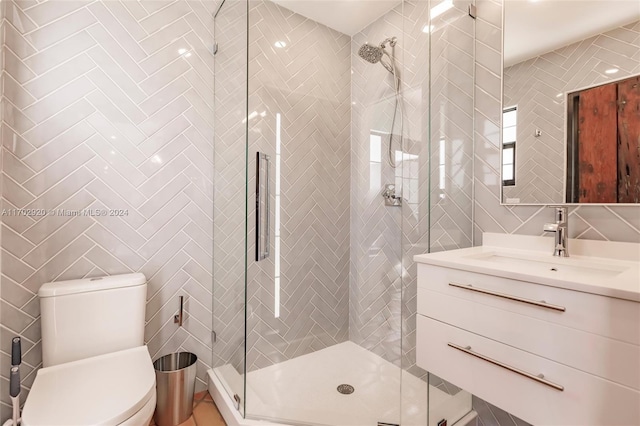 bathroom with an enclosed shower, vanity, toilet, and tile walls