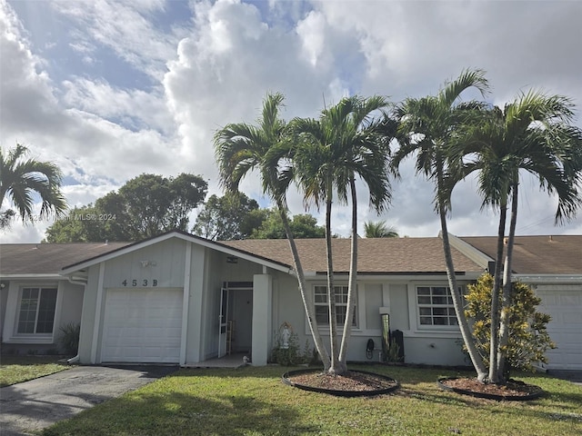 single story home featuring a garage and a front yard