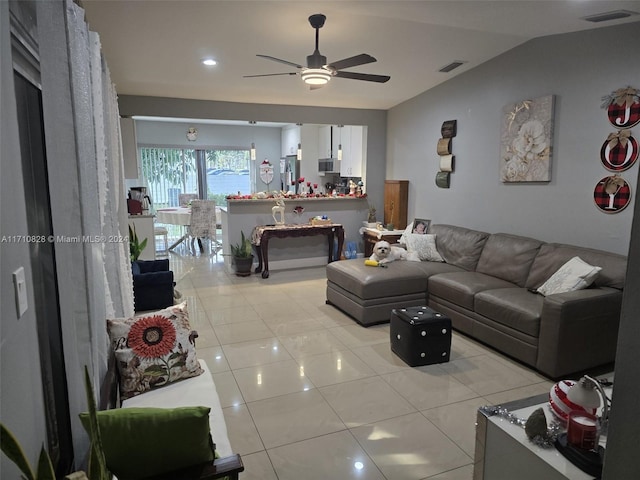 tiled living room with ceiling fan and lofted ceiling