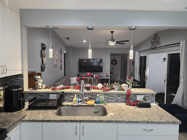 kitchen featuring backsplash, ceiling fan, sink, decorative light fixtures, and white cabinets