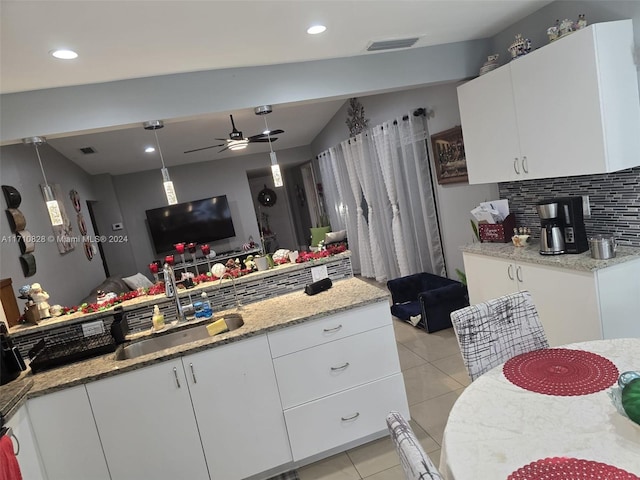 kitchen featuring ceiling fan, white cabinetry, and sink