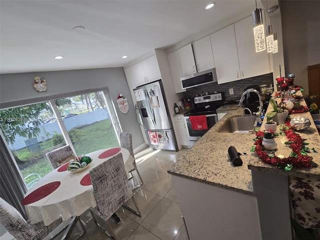 kitchen with white cabinets, sink, vaulted ceiling, decorative light fixtures, and stainless steel appliances