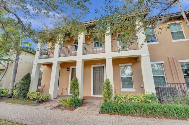 view of front of home with a balcony and stucco siding