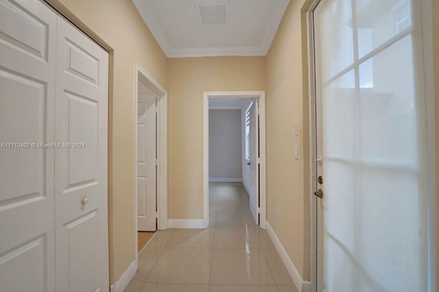 hall with light tile patterned floors and crown molding