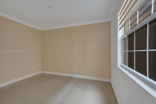 empty room featuring light tile patterned flooring, baseboards, and ornamental molding
