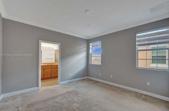 empty room featuring attic access, light carpet, baseboards, ornamental molding, and visible vents