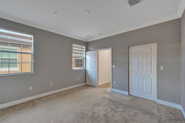 unfurnished bedroom featuring light carpet and crown molding