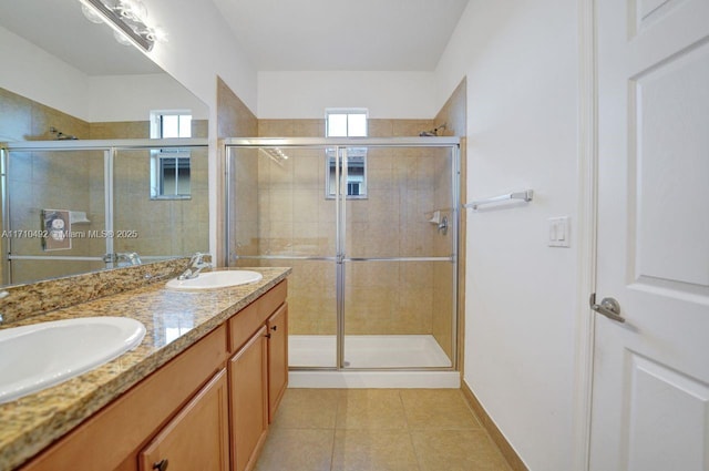 full bath with tile patterned floors, a sink, and a stall shower