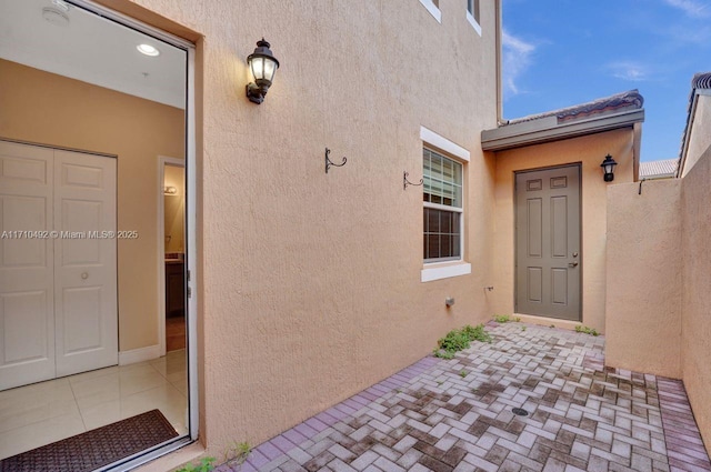 entrance to property featuring stucco siding