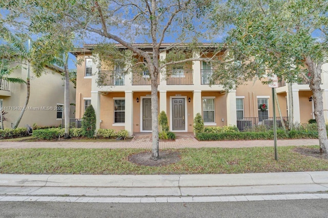 multi unit property with stucco siding and a balcony