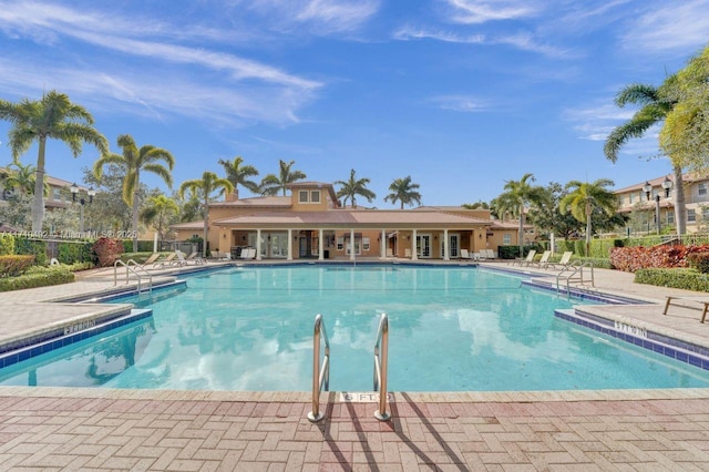 community pool with fence and a patio area
