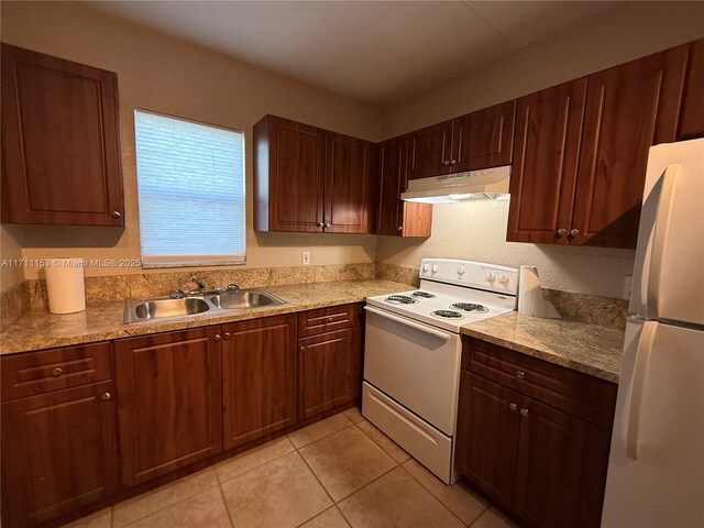 kitchen with light tile patterned floors, white appliances, and light stone counters