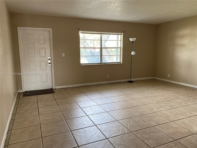 tiled foyer entrance with a textured ceiling