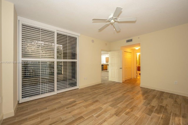 spare room with ceiling fan and wood-type flooring