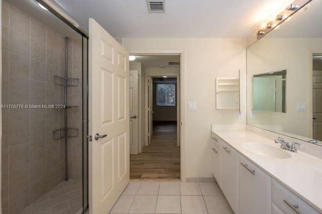 bathroom with a shower with door, vanity, and wood-type flooring