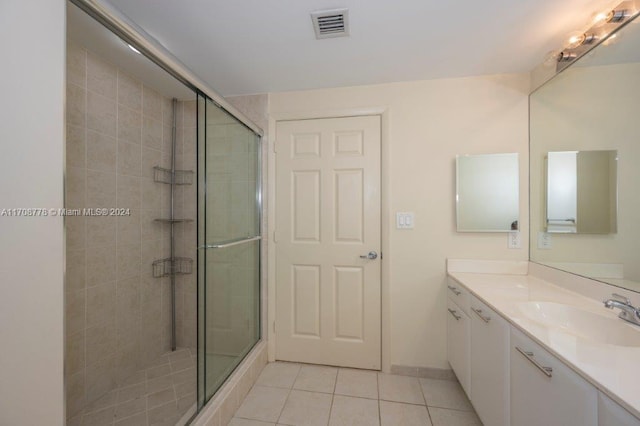 bathroom featuring tile patterned flooring, vanity, and an enclosed shower