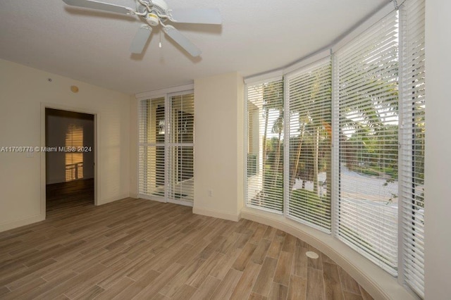 empty room with ceiling fan and wood-type flooring