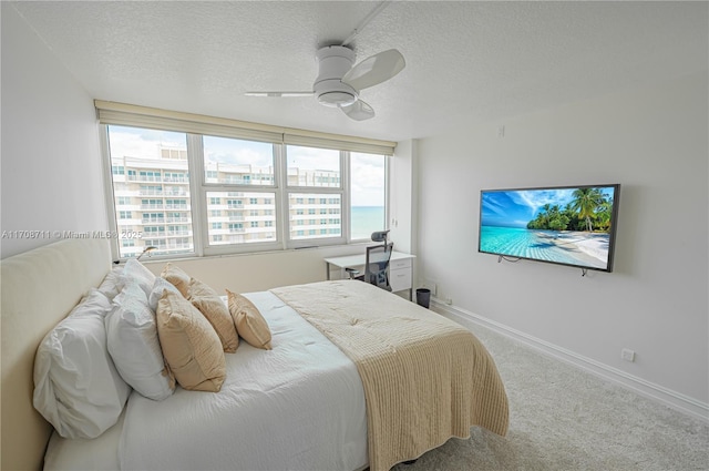 bedroom featuring carpet, ceiling fan, and a textured ceiling