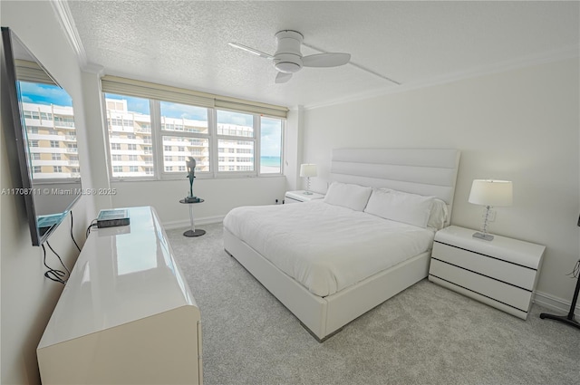 bedroom with a textured ceiling, ceiling fan, light colored carpet, and crown molding