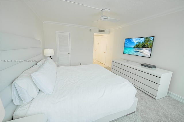 bedroom with ceiling fan, a closet, crown molding, and light carpet