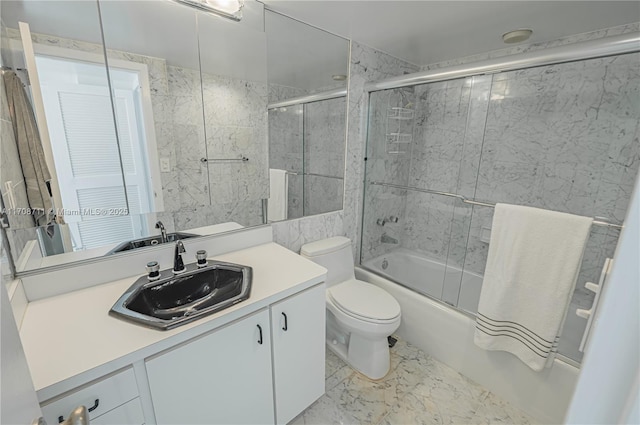 full bathroom featuring vanity, toilet, tile walls, and enclosed tub / shower combo