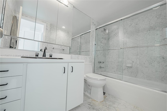 full bathroom with vanity, bath / shower combo with glass door, tile walls, and toilet