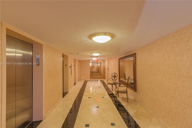 corridor featuring a textured ceiling and elevator