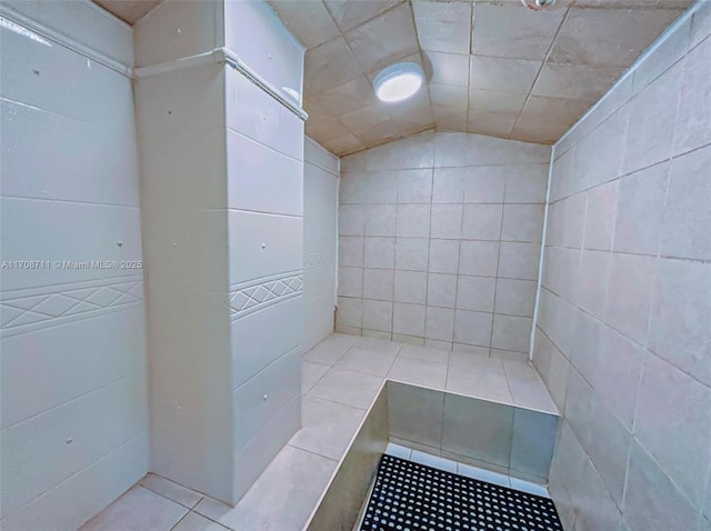 bathroom with tile patterned flooring and vaulted ceiling